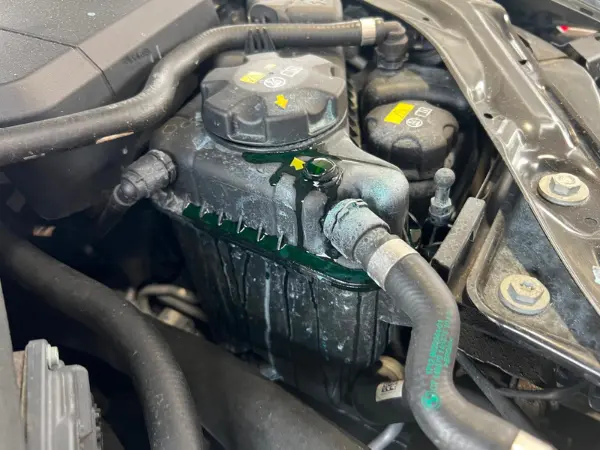 Leaking engine coolant expansion tank receiving professional, quality cooling system service by BMW and More Auto Care LLC.