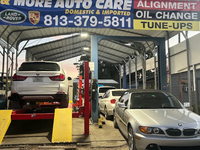 A white BMW X5 on a hydraulic alignment lift alongside a silver BMW convertible at BMW and More Auto Care serving Palm Harbor.