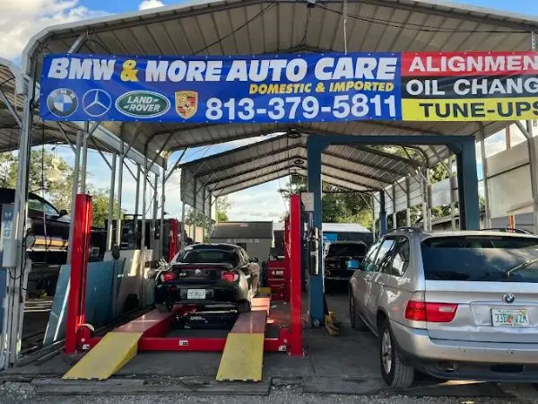 A black BMW Z4 on an alignment lift and a silver BMW X5 at BMW and More Auto Care for professional auto repairs in Riverview, FL.
