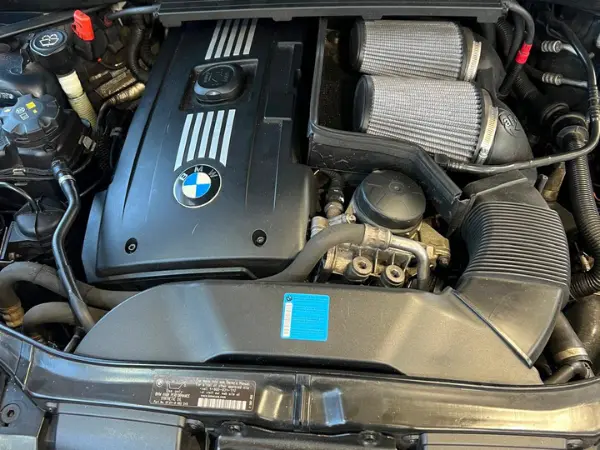 Engine bay with twin performance intakes receiving an affordable oil & filter replacement at BMW and More Auto Care LLC